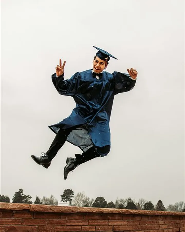 A graduate jumping in celebration